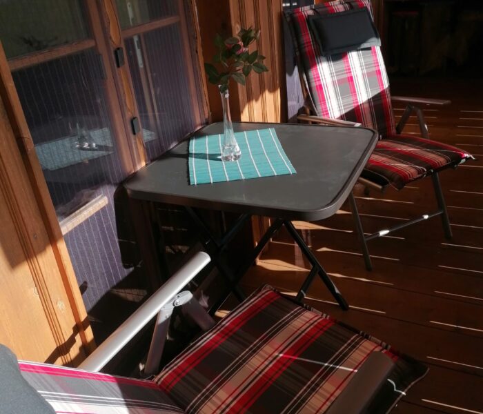 Gemütliche Sitzecke auf dem Balkon mit Blick auf die Berge